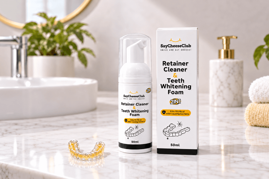 SayCheeseClub Retainer Cleaner and Teeth Whitening Foam with a yellow-stained clear retainer on a bathroom counter.