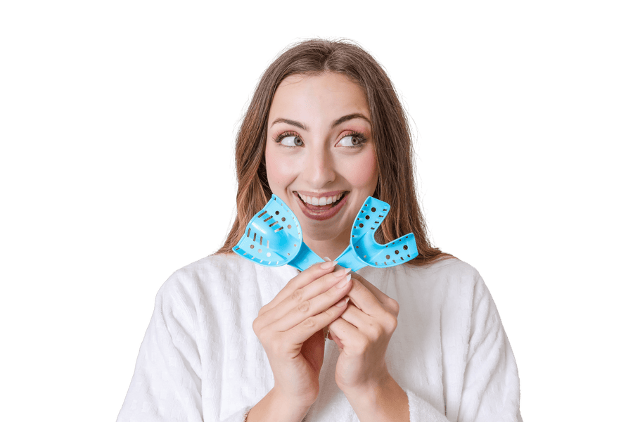 Woman smiling holding up two blue impression trays from SayCheeseClub 