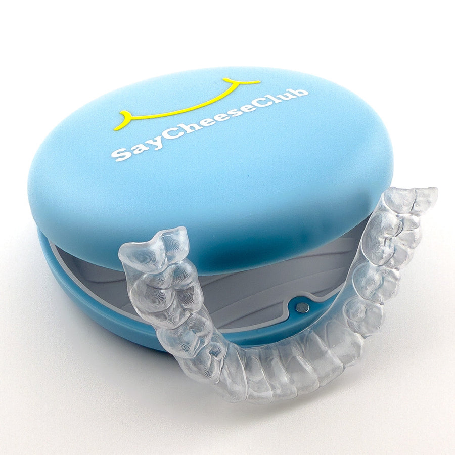 Clear Lower Retainer sitting against a Blue SayCheeseClub Retainer Case