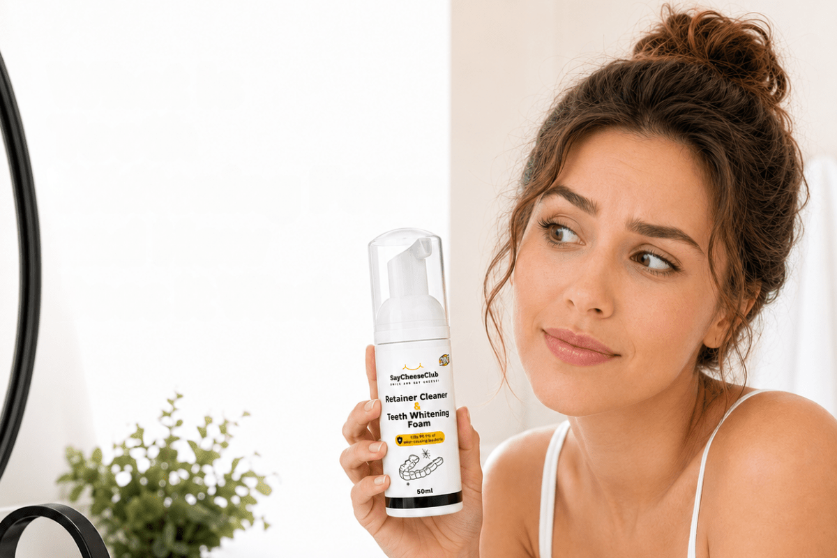 Woman holding SayCheeseClub Retainer Cleaner and Teeth Whitening Foam in front of a bathroom mirror