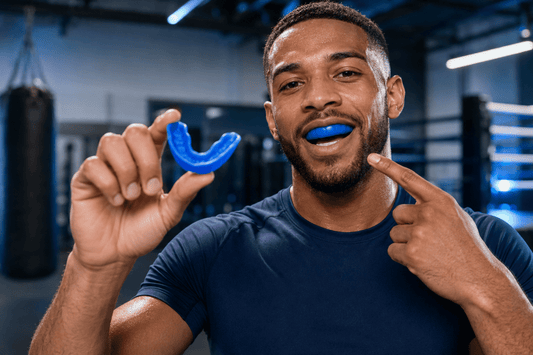 Male athlete showing a custom sports mouthguard before training 