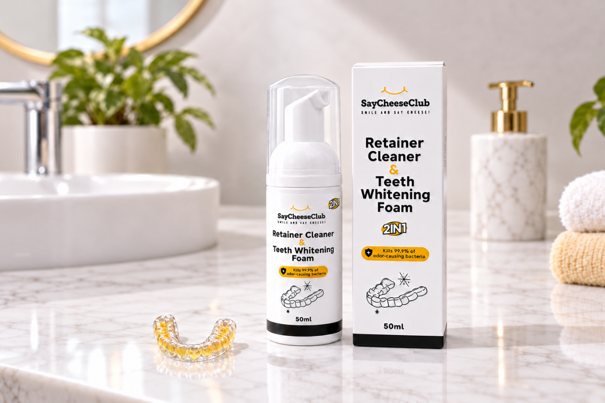SayCheeseClub Retainer Cleaner and Teeth Whitening Foam with a yellow-stained clear retainer on a bathroom counter.