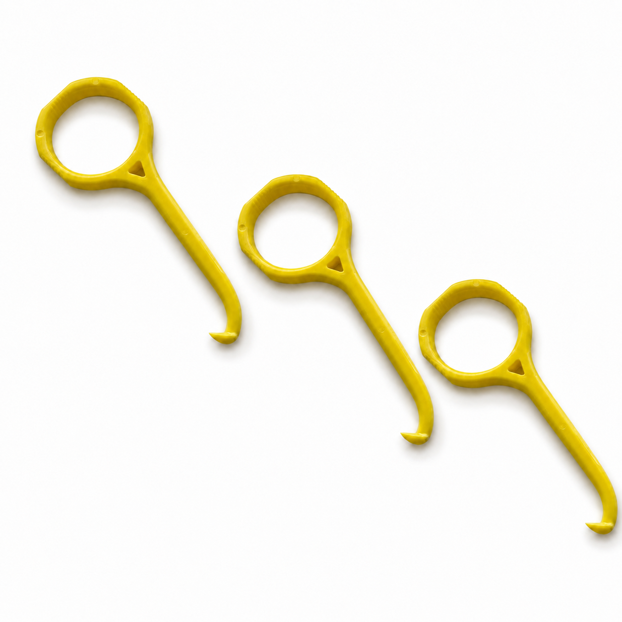 Three bright yellow plastic aligner removal tools arranged diagonally on a clean white background.
