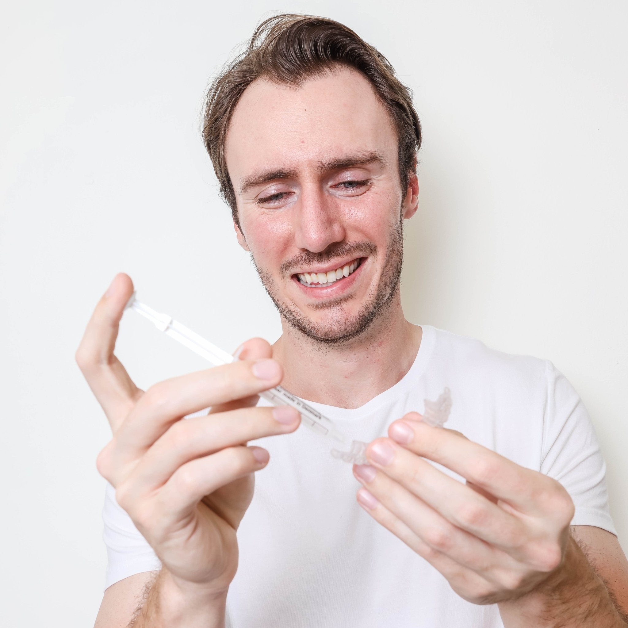 Man apply SayCheeseClub teeth whitening gel to whitening tray