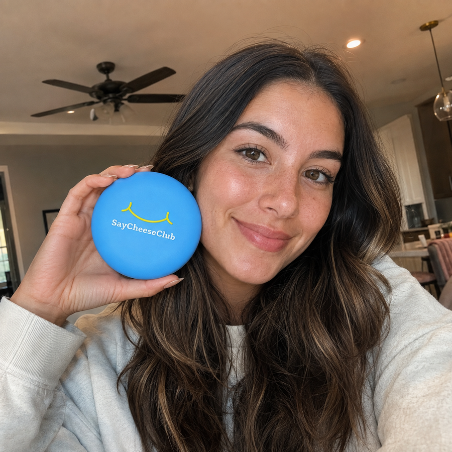 A woman holds a blue SayCheeseClub case