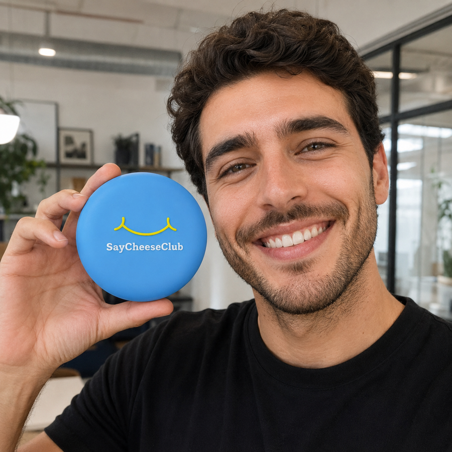 A man holds a blue SayCheeseClub case