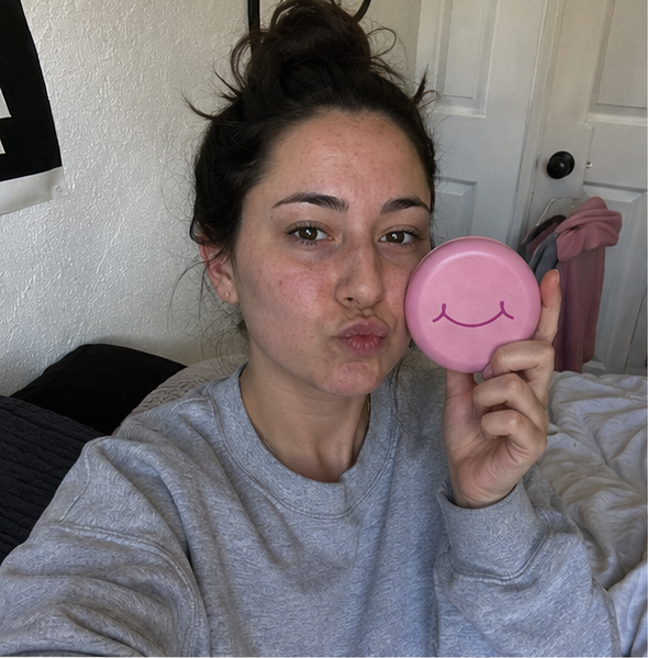 A woman holds a pink SayCheeseClub case near her face