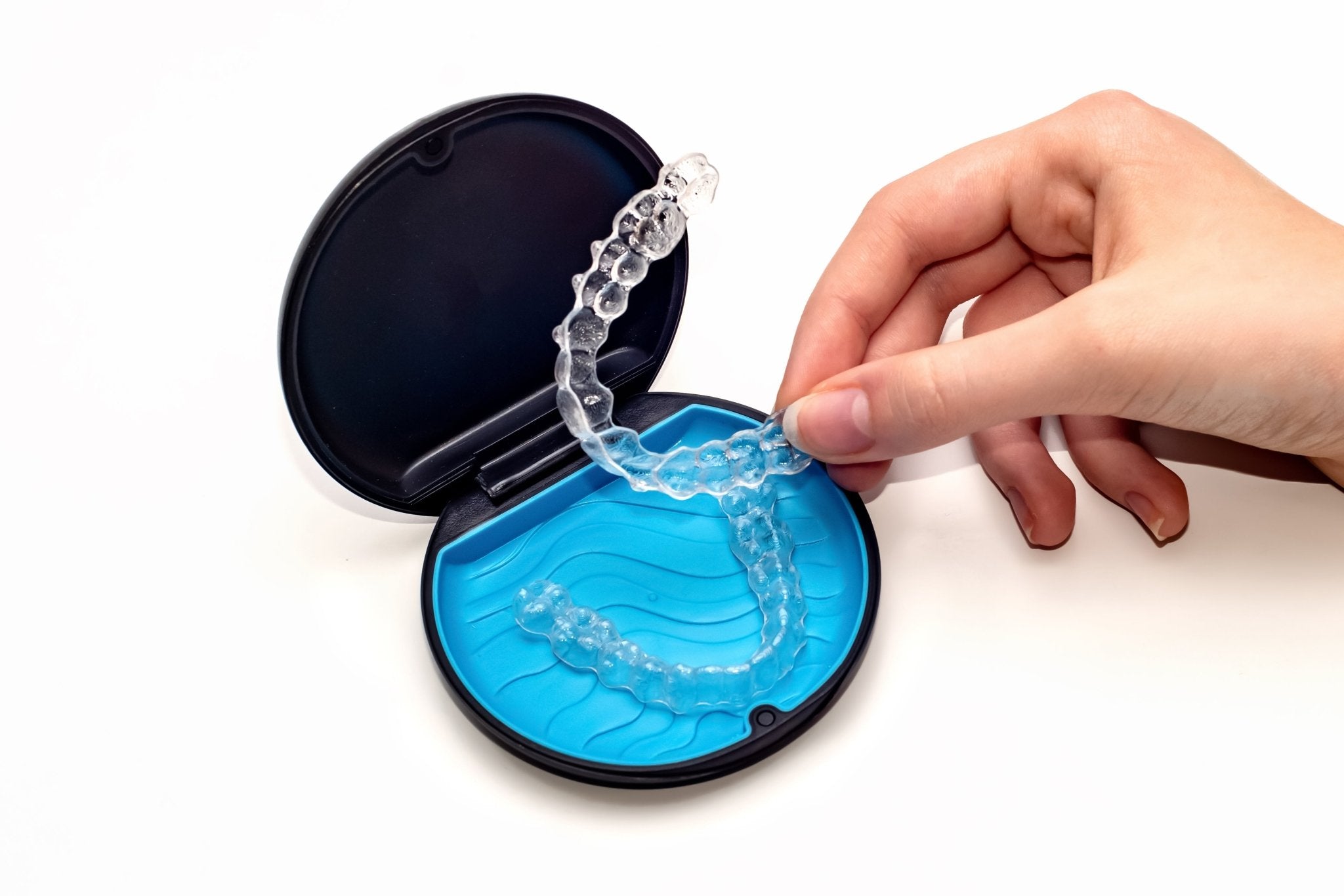 Clear retainers in a protective case, showcasing SayCheeseClub’s custom dental retainers designed to prevent teeth from shifting.