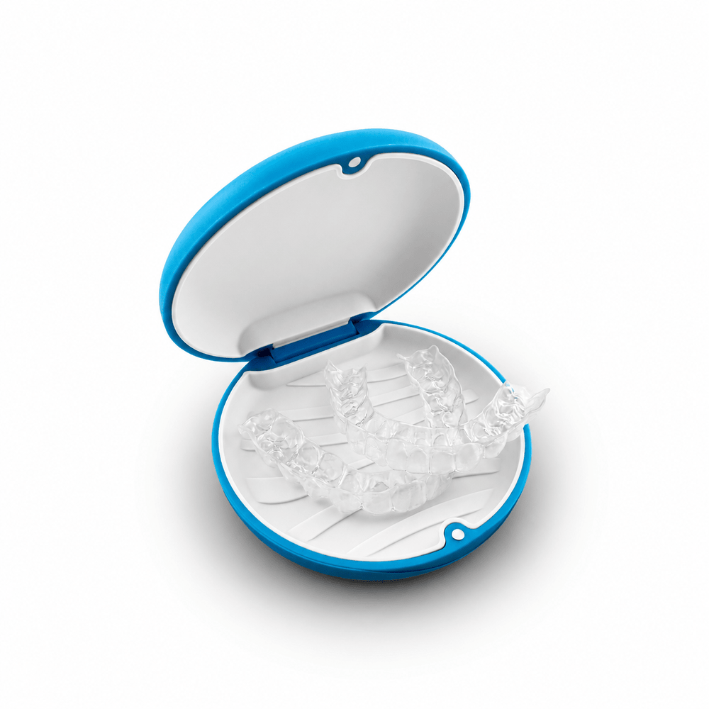 SayCheeseClub custom clear upper and lower dental retainers in an open blue and white storage case